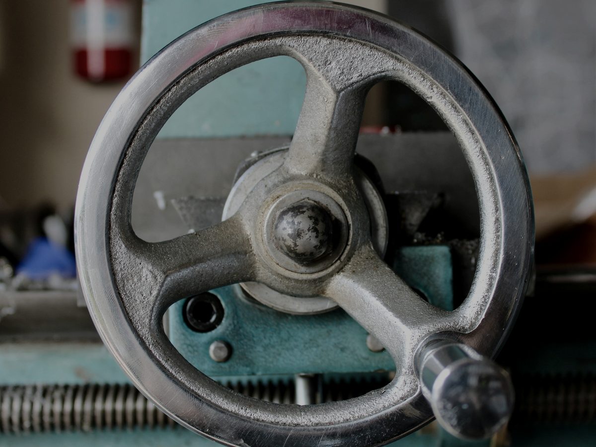 Close-up of a metal handwheel on a machine.